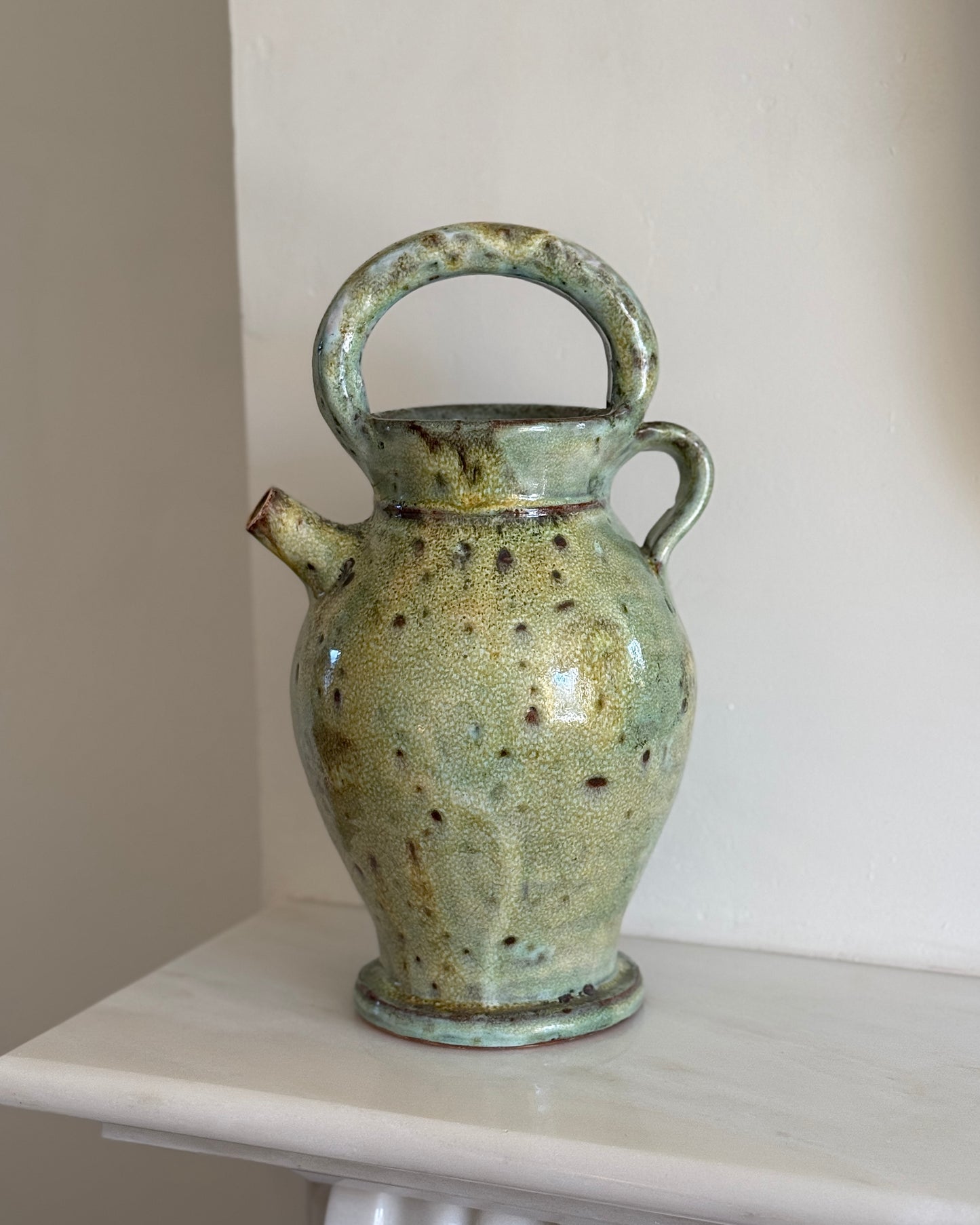 A large glazed ceramic vessel with a mottled two-tone green finish, made in South of France circa 19th Century. Signed Vallauris. The vessel features a large rounded handle on top, a smaller to the right and a small spout.