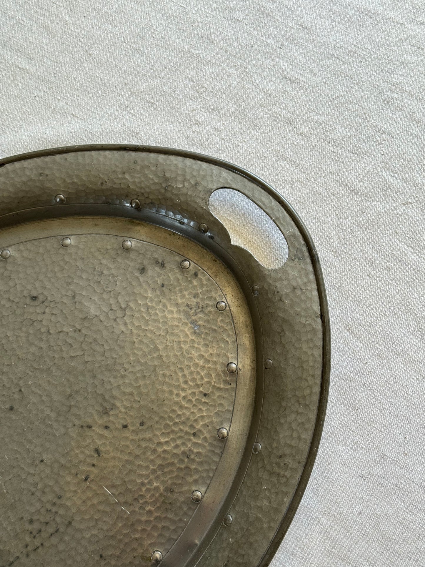 Close‑up of pewter tray’s hammered finish and smooth patina