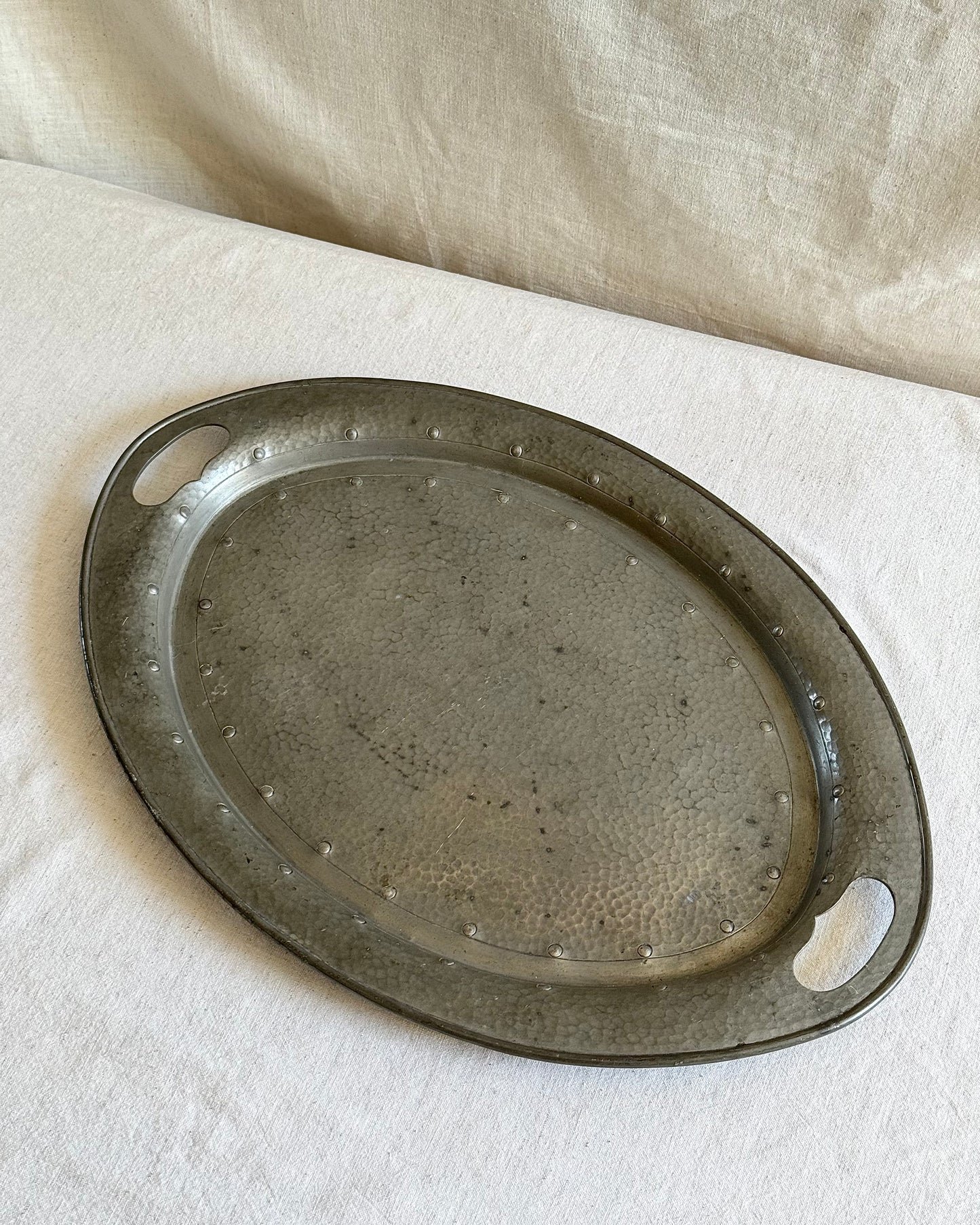 Hammered pewter tray with built‑in handles, top view showing textured surface
