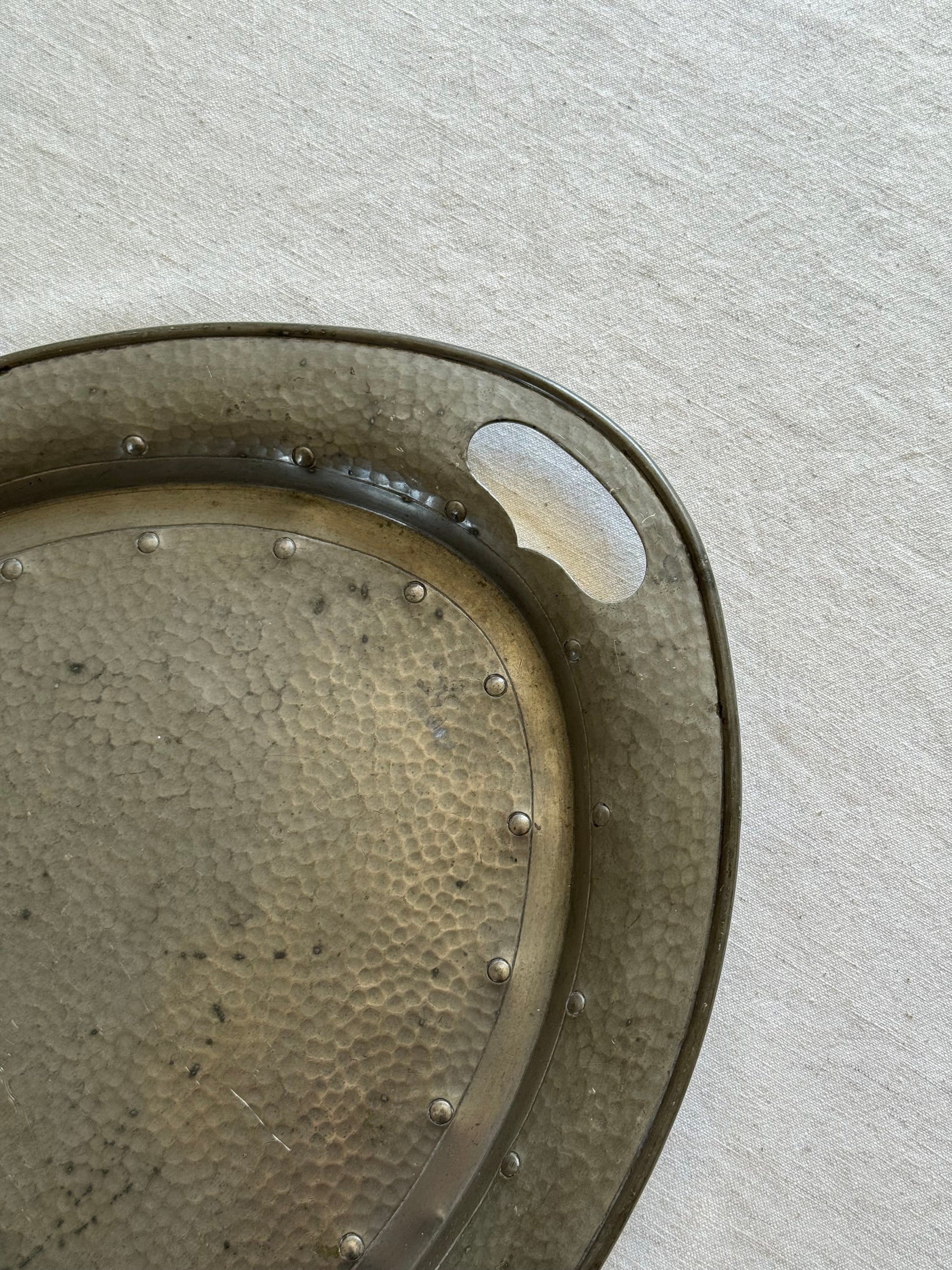 Close‑up of pewter tray’s hammered finish and smooth patina