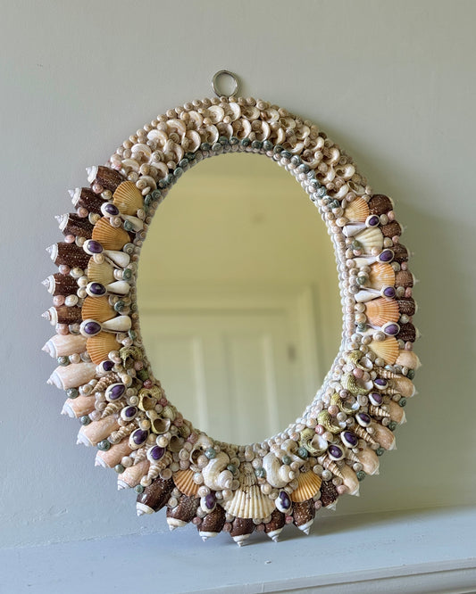 French mid-century shell-encrusted oval mirror against green wall